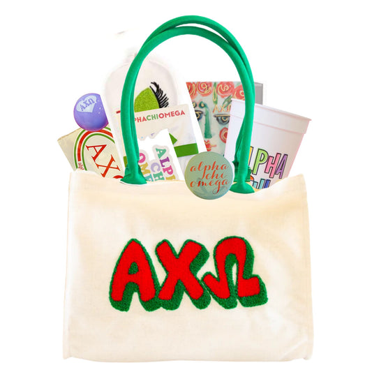 AXO tote bag containing a variety of items that all have the greek letters on them, including a cup, sticker, pin, lip balm, box, note pad, and sleep mask