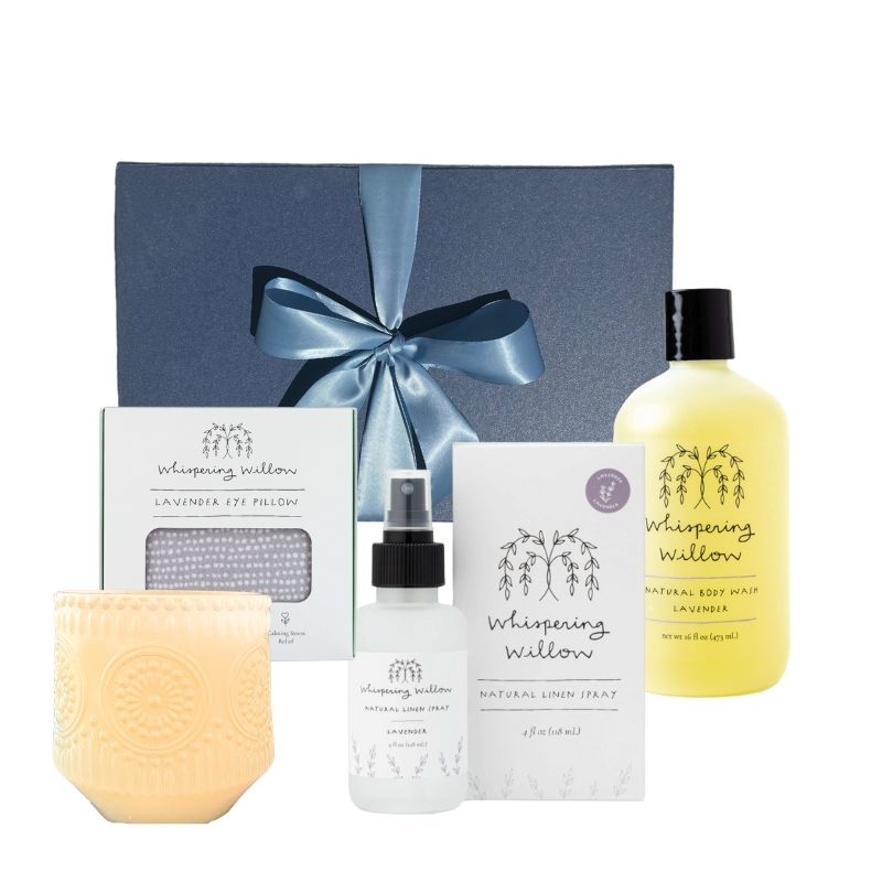 Luxury lavender self-care gift box standing upright with body wash, linen spray, eye pillow, and soy candle arranged in front, showcasing all included items