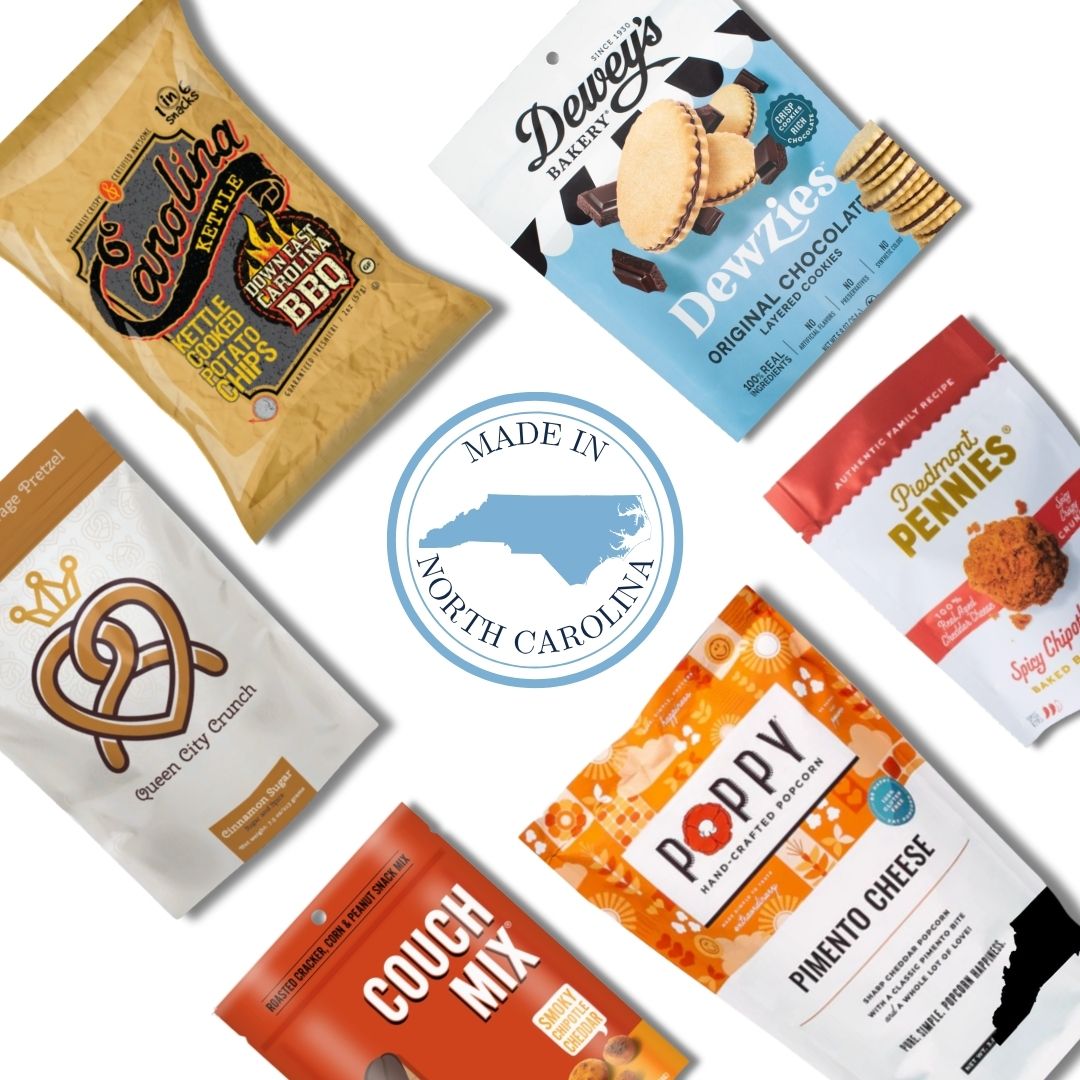 Flat lay image of the Carolina Crafted Gift Basket contents, featuring a variety of sweet and savory North Carolina-made snacks with a Made in NC emblem at the center.