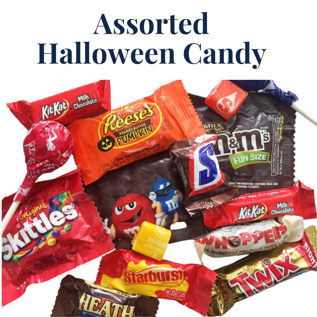 Assorted Halloween candy including Kit-Kat, Reese's, Skittles, and M&M's on a white background.