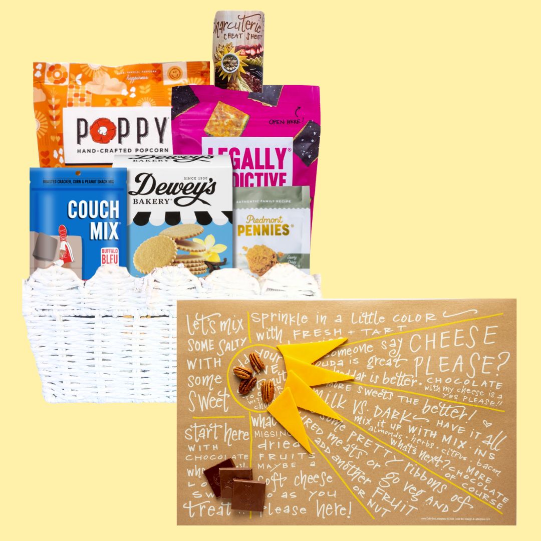 Sunburst Charcuterie Gift Basket with open cheat sheet against a light yellow background, highlighting NC-made gourmet treats like cookies, popcorn, and cheese wafers