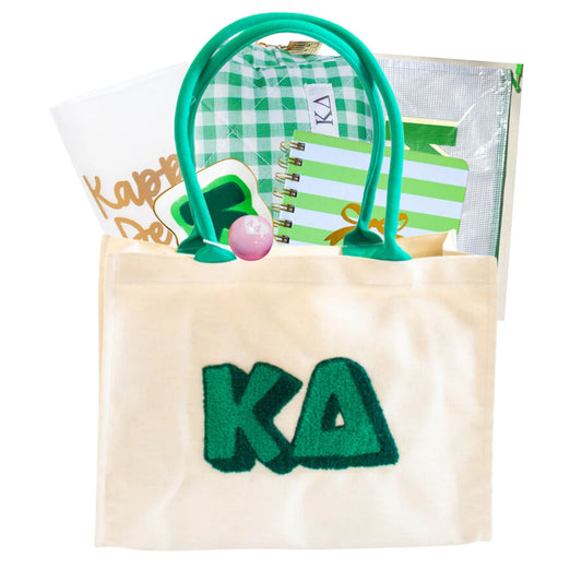 Tote bag with 'KD' lettering, green handles, and a notebook inside on a white background. Also includes other Kappa Delta items to celebrate bid day, initiation, or big sister, little sister