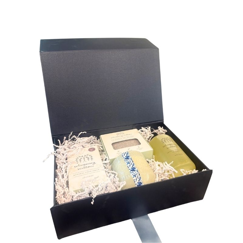 Open luxury gift box filled with lavender self-care products including a soy candle, linen spray, body wash, and eye pillow, beautifully arranged for gifting