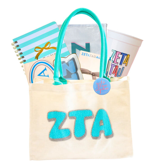 Tote bag with 'ZTA' letters, books, and a cup on a white background for bid day, initiation, or big sis/lil sis