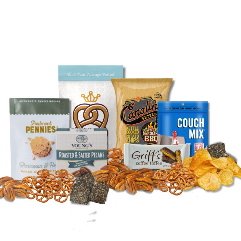 Carolina Sampler gift items displayed on a tabletop with loose BBQ chips, toffee, pecans, and pretzels