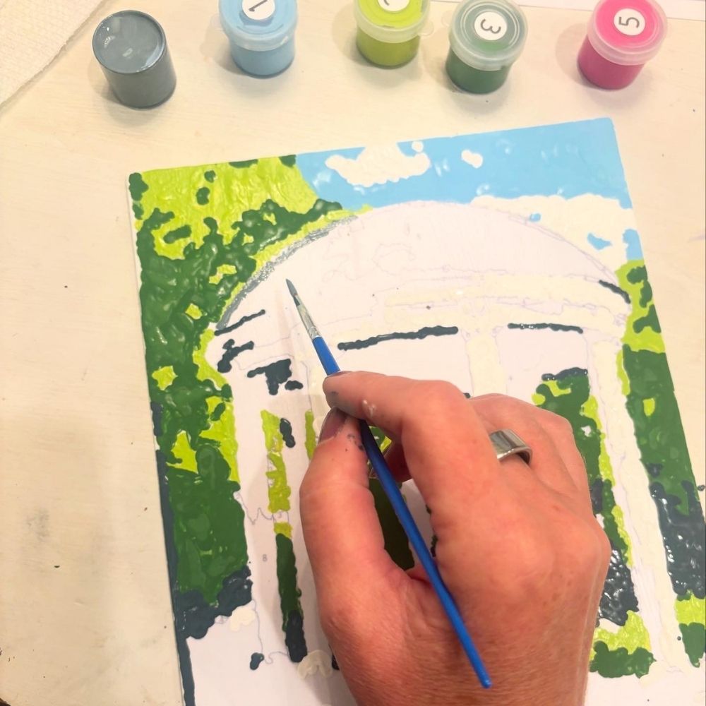 action shot of person painting Old Well in Chapel Hill at UNC using Old Well Paint by Number Kit