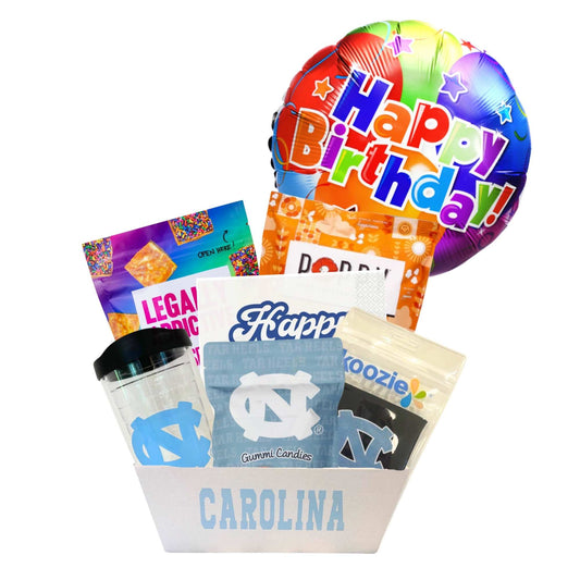 gift basket containing cookie cake, NC made Legally Addictive cookies, UNC stickers, UNC gummy candies, Carolina BBQ chips, and a UNC insulated cup to be delivered to UNC students at Chapel Hill.