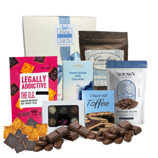 Chocolate Lover’s Delight gift box displayed on a tabletop with all contents arranged around it, including chocolate cookies, toffee, chocolate bars, truffles, chocolate potato chip clusters, and chocolate-covered pecans made in North and South Carolina.