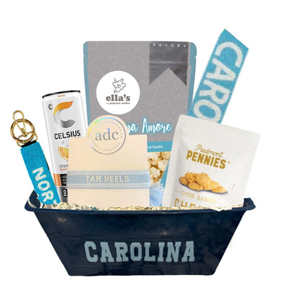 UNC Chapel Hill Game Day Gift basket filed with Carolina blue popcorn that is made in North Carolina, a beaded UNC purse strap, a beaded Chapel Hill keychain, a Tar Heels woven bracelet, and Piedmont Pennies that are NC made. 