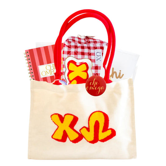 Tote bag with 'chi omega' letters, notebook, and other items on a white background, perfect for bid day, initiation, or big sis/lil sis