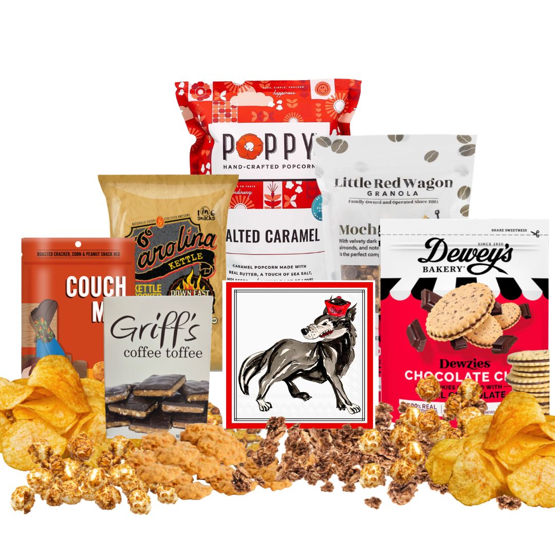 NC State-themed gift basket contents arranged on a countertop with small piles of each snack in front, showcasing red-packaged North Carolina-made gourmet treats