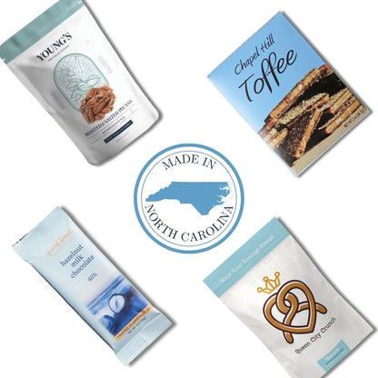 Carolina Blue gourmet items arranged around Made In North Carolina emblem for event welcome box