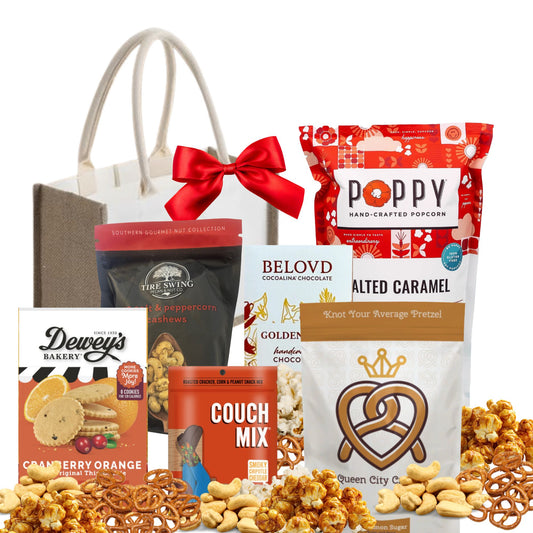 Assorted snack items including pretzels, nuts, and chocolate with a gift bag and bow on a white background.