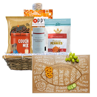 A Football Game Day Charcuterie Gift Basket featuring North Carolina-made snacks and a football-shaped charcuterie cheat sheet in front. Includes BBQ chips, spicy cheese biscuits, toffee popcorn, and more, presented in a reusable basket. Perfect for tailgates and parties.