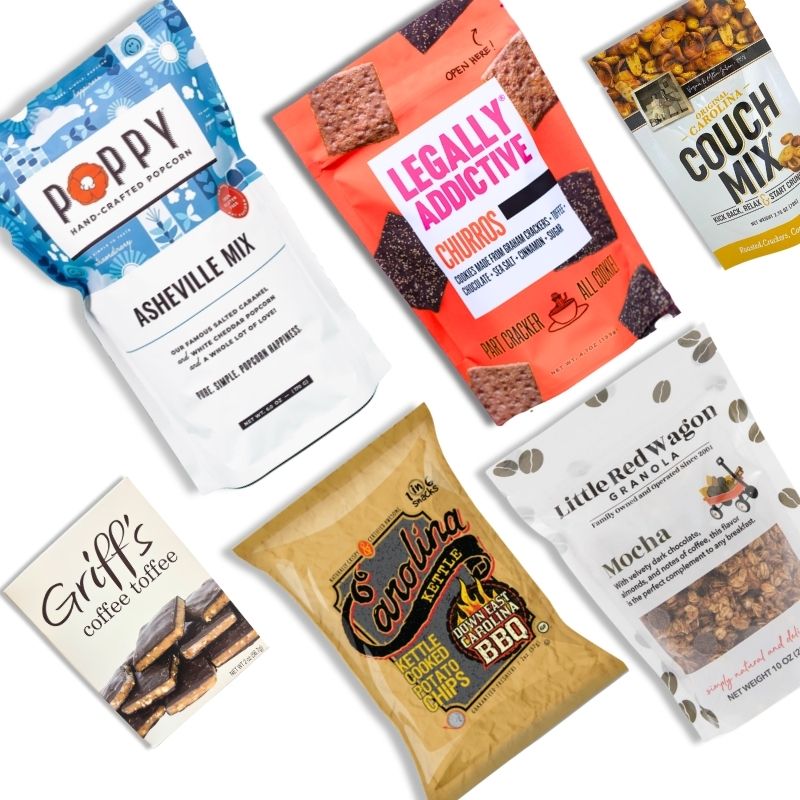 Flat lay of the Carolina Snack Box contents including NC-made popcorn, chips, granola, cookies, toffee, and snack mix, arranged neatly on a white background