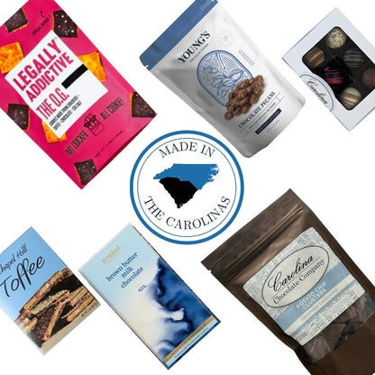 Flat lay of the Chocolate Lover’s Delight gourmet gift box featuring artisan chocolate cookies, toffee, chocolate bars, truffles, chocolate clusters, and chocolate-covered pecans, with a central emblem reading “Made in the Carolinas,” highlighting North and South Carolina–made sweets.