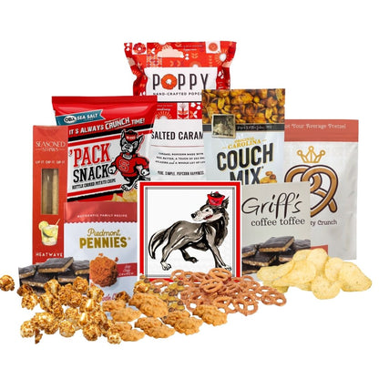 NC State-themed gift basket contents arranged on a countertop with small piles of each snack in front, showcasing red-packaged North Carolina-made gourmet treats