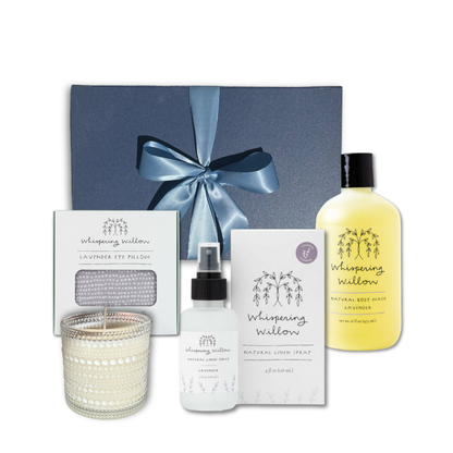 Luxury lavender self-care gift box standing upright with body wash, linen spray, eye pillow, and soy candle arranged in front, showcasing all included items