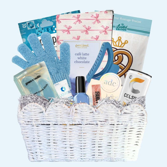 UNC Chapel Hill gift basket full of Carolina blue gifts for girls who enjoy self care, including a Tar Heels game day bracelet, UNC chocolates, cosmetic items, and made in North Carolina snacks