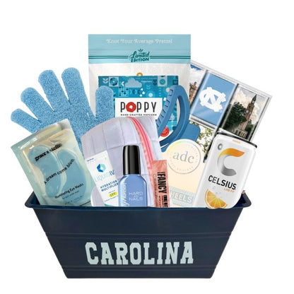 UNC Chapel Hill gift basket full of Carolina blue gifts for girls who enjoy self care, including a Tar Heels game day bracelet, UNC chocolates, cosmetic items, and made in North Carolina snacks
