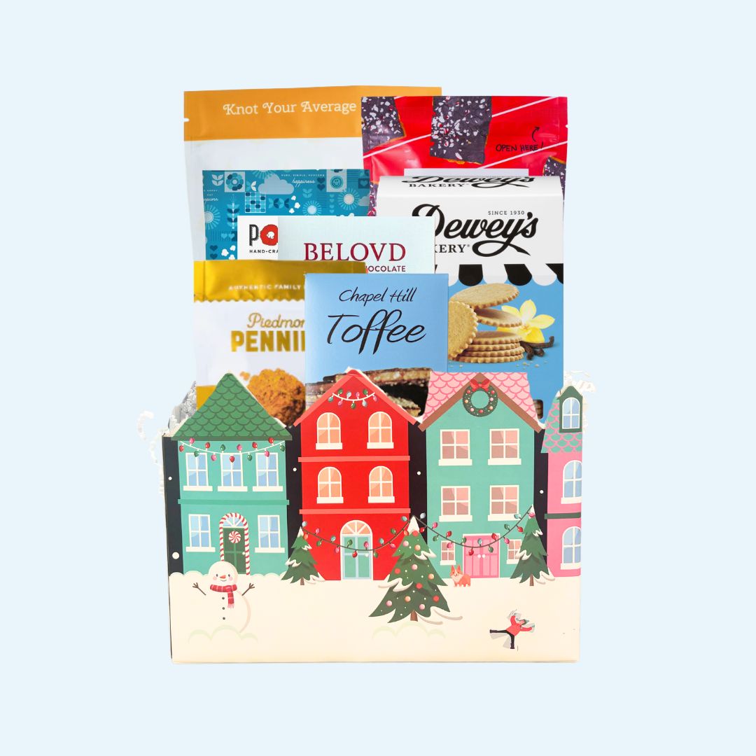 Stunning winter-themes gift box containing gourmet treats and snacks that are locally made in North Carolina, including Legally Addictive toffee cookies, Queen City Crunch pretzels, Deweys Bakery vanilla thins, Chapel Hill toffee, Piedmont Pennies  cheese wafers, and north carolina made food products.