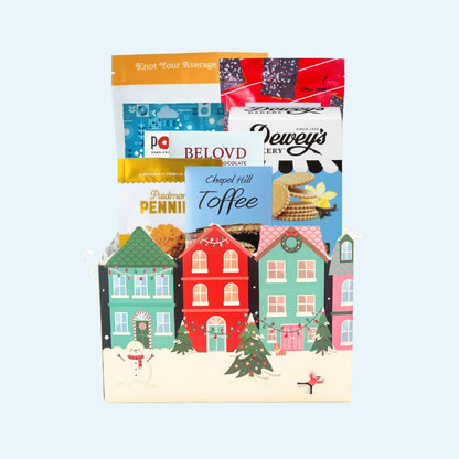 Stunning winter-themes gift box containing gourmet treats and snacks that are locally made in North Carolina, including Legally Addictive toffee cookies, Queen City Crunch pretzels, Deweys Bakery vanilla thins, Chapel Hill toffee, Piedmont Pennies  cheese wafers, and north carolina made food products.