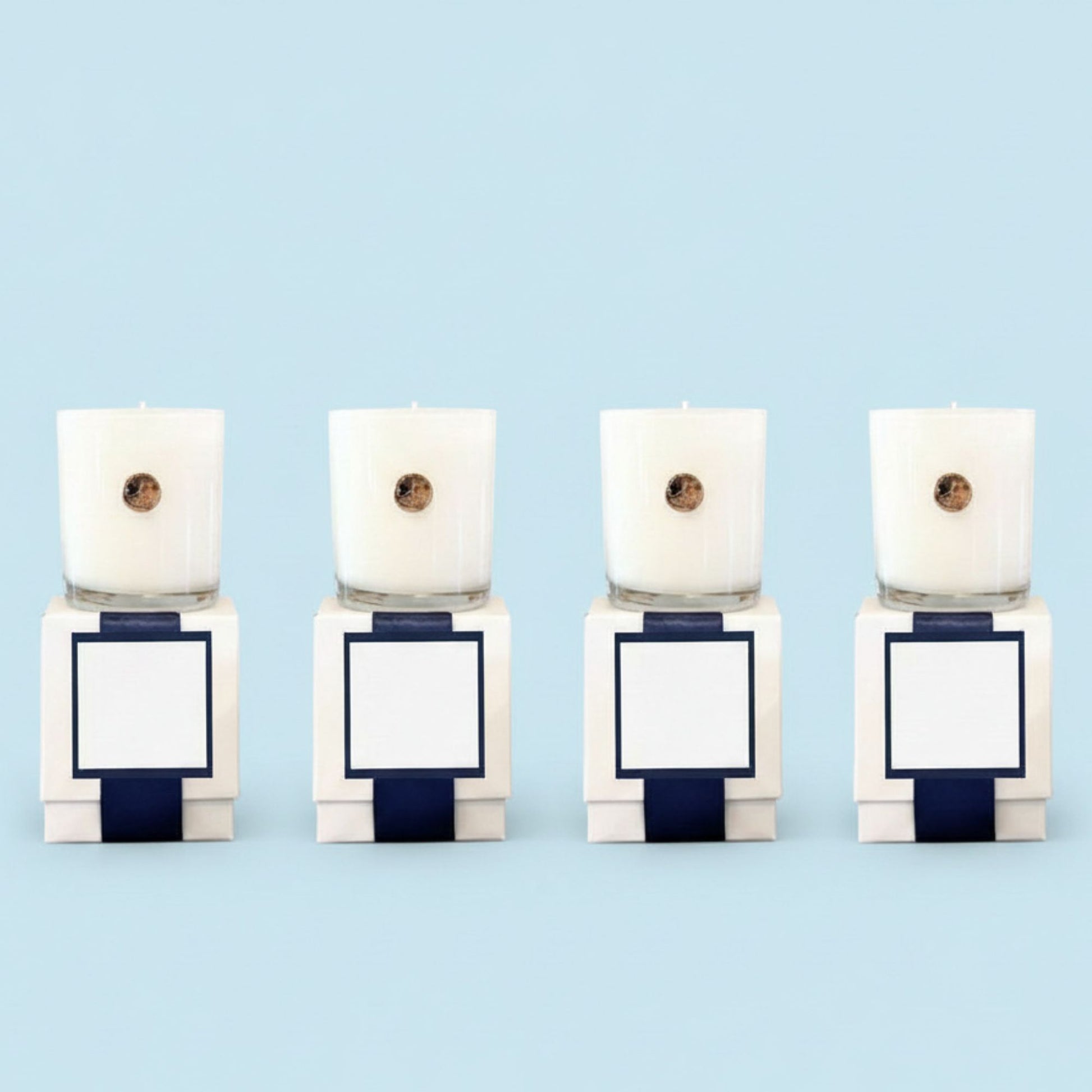 Four white custom branded corporate candles with gold dogwood emblem in luxury gift boxes, North Carolina artisan gifts for businesses