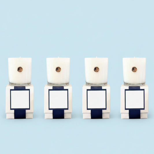 Four white custom branded corporate candles with gold dogwood emblem in luxury gift boxes, North Carolina artisan gifts for businesses