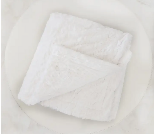 A plush faux fur lap blanket neatly folded to show its soft texture and reversible design—perfect for cozy gifting or relaxing at home.