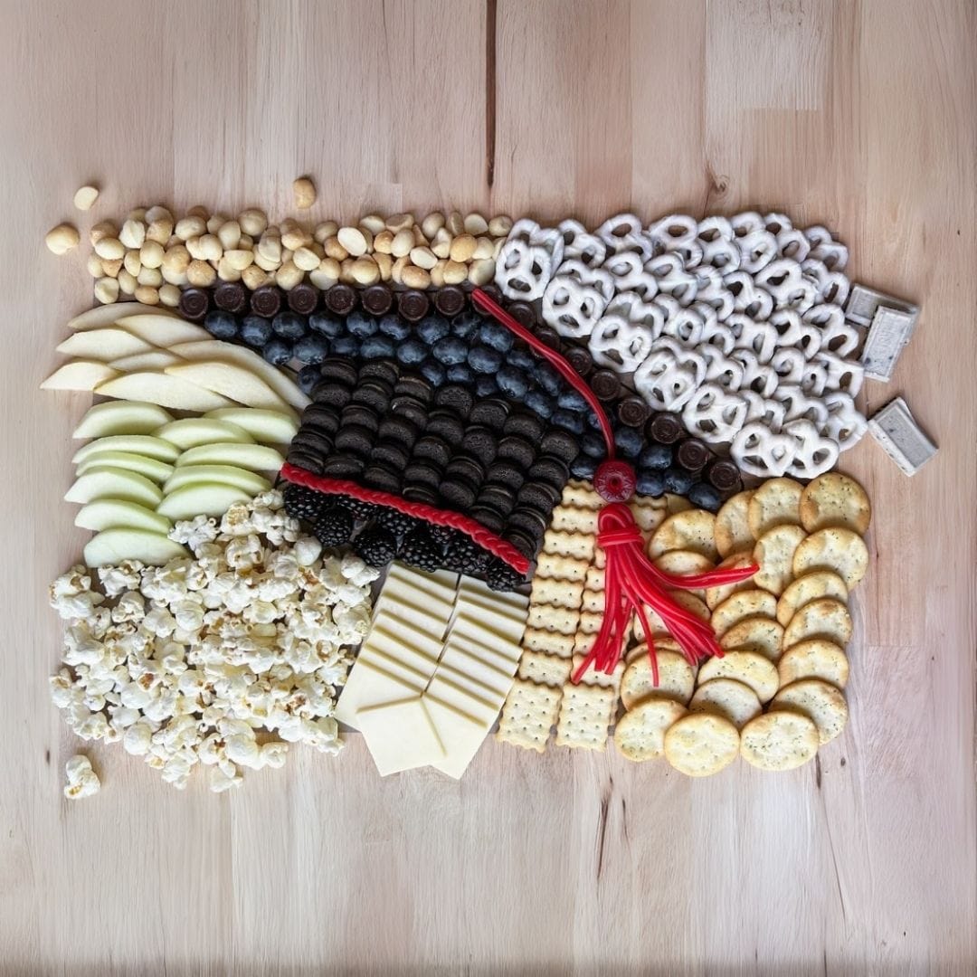 Graduation charcuterie mat with North Carolina gourmet treats and artisan snacks for grad parties