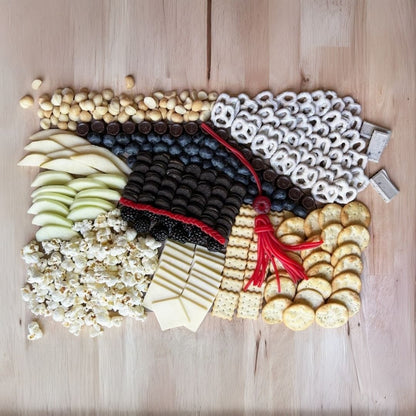 Graduation charcuterie mat with North Carolina gourmet treats and artisan snacks for grad parties