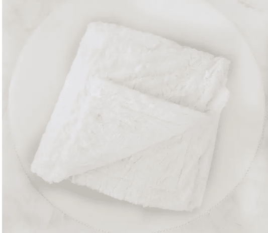 Folded white blanket on a light gray background for sympathy gift or get well