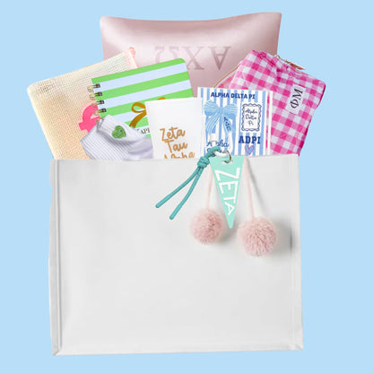 UNC bid day gift bag contents including satin pillowcase, gingham cosmetic bag, sorority notebook, socks, stickers, and pennant keychain