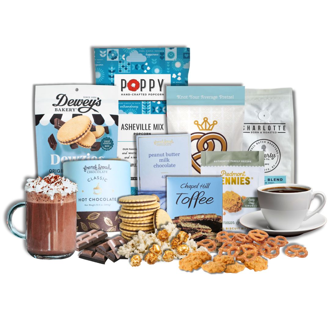 Winter Luxe Gourmet gift basket contents displayed on a kitchen counter  with North Carolina artisan snacks, popcorn, pretzels, chocolate, toffee, coffee, and hot chocolate arranged neatly with piles of each treat in front of its packaging.